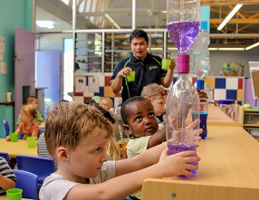 Children conducting plastic bottle and coloured water experiment