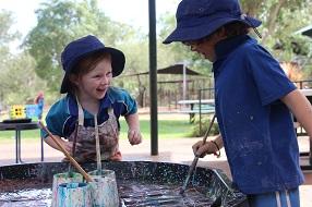 Two children in out of school hours care outside painting