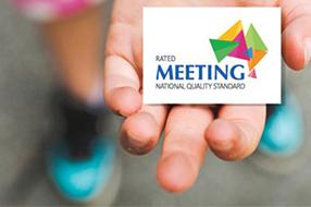 Hand holding card with Meeting NQS logo on