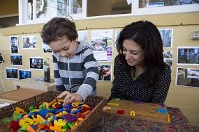 KU Lance educator with child playing with blocks