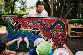 Chad Briggs with Indigenous artwork at service