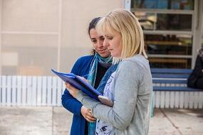 Two educators looking at document outdoors