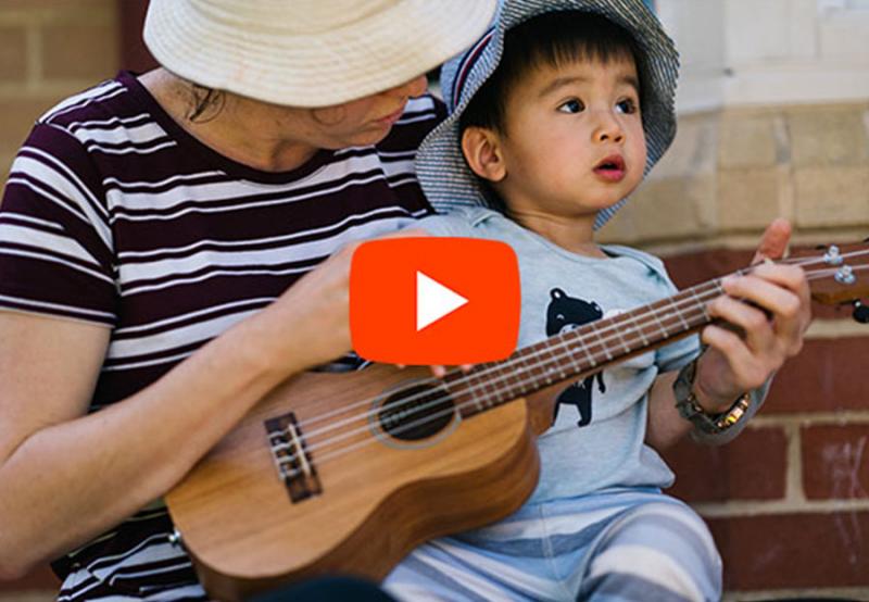 Educator and child playing guitar