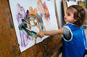 Child painting at easel