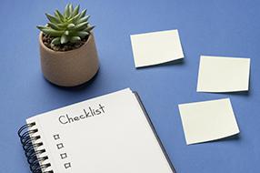 Notepad with checklist, sticky notes and plant pot