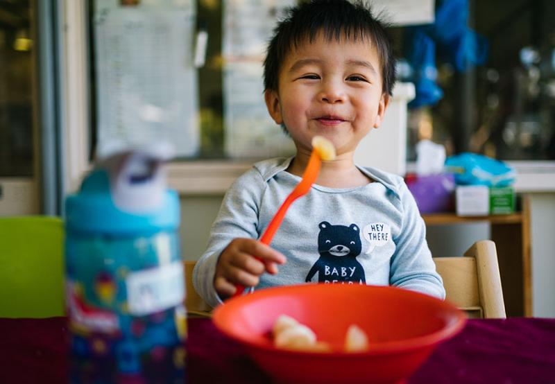 Child eating fruit and smiling