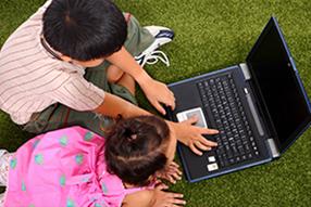 Two children using laptop
