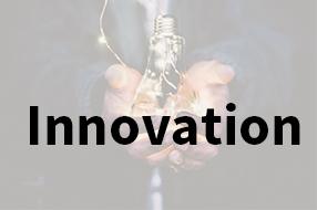 Person holding lit lightbulb in hands with text 'Innovation' written over the top