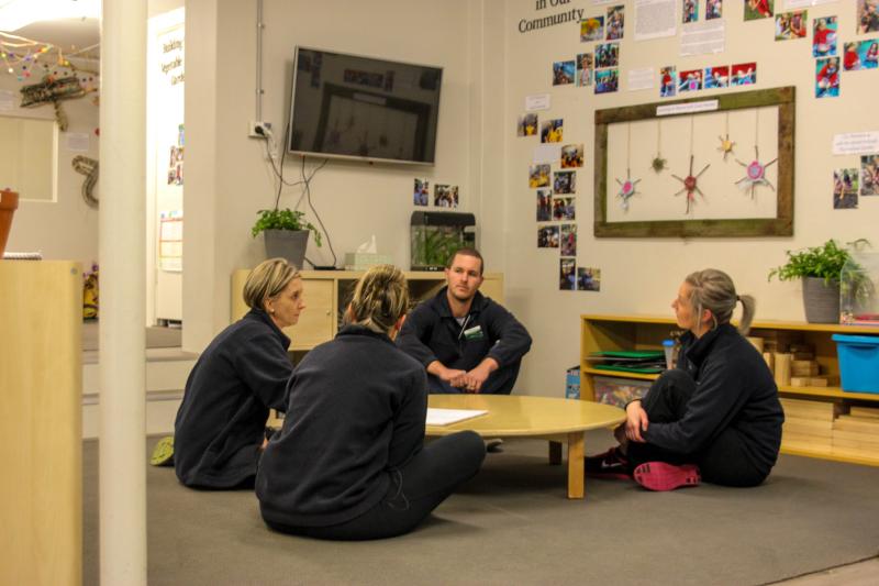 image of service staff sitting on floor at a meeting