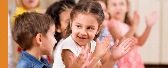 closeup photo of children inside clapping hands in circle